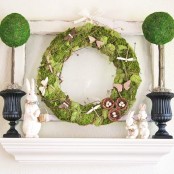 a fresh Easter mantel with moss topiaries, a moss wreath with butterflies and nests and bunnies