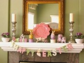 a pastel Easter mantel with a bunting, fake bunnies, potted blooms and plates