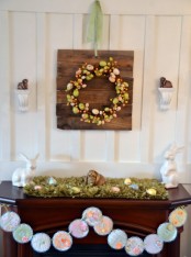 pastel Easter mantel styling with a pastel egg wreath. faux moss with eggs and bunnies and a vintage fabric bunting