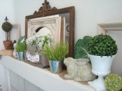 a fresh spring mantel with boxwood topiaries, potted grass and blooms, fake bunnies