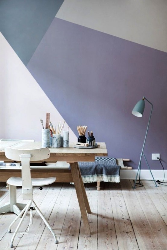 a Scandinavian home office with a pastel geometric wall, a wooden desk, a vintage white chair, a floor lamp and a daybed