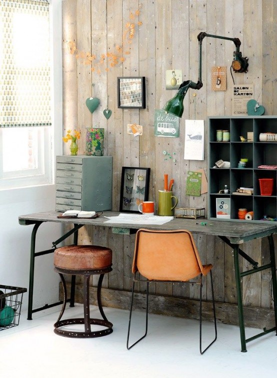 an industrial home office with reclaimed wood walls, with vintage storage units placed right on an industrial desk compose of aged wood and metal