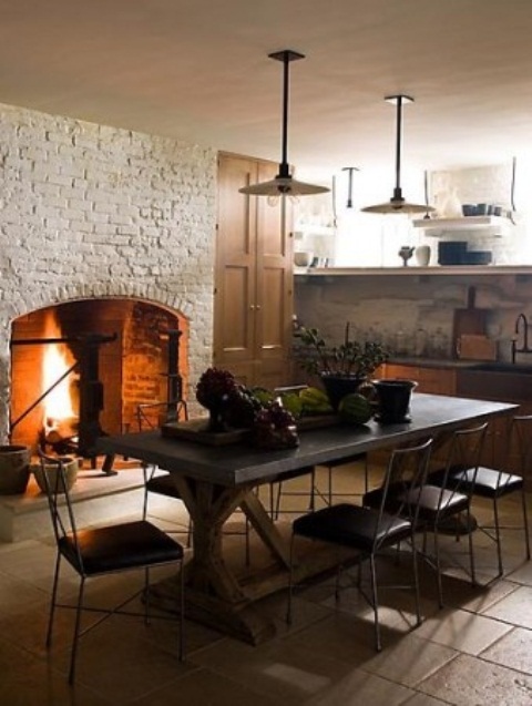 a large fireplace clad with white brick and a concrete table make up a cool space and add texture to the space