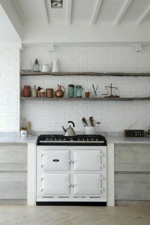 a white brick wall adds texture to the space and matches the neutral kitchen decor at the same time