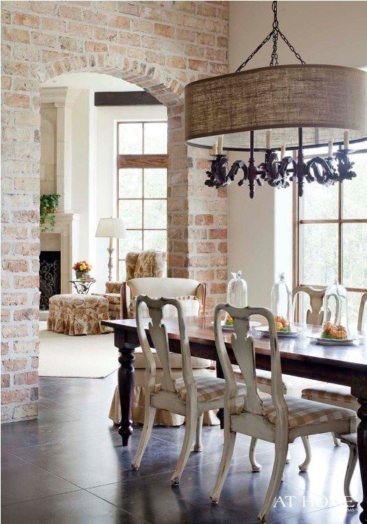 exposed red brick walls in the dining room add texture and make this refined space less formal and more relaxed