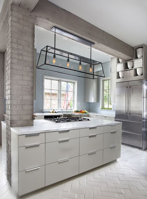 light blue brick walls and a taupe brick pillar complete the space adding subtle touches of color to the kitchen