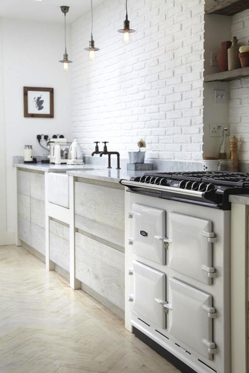 a white brick wall perfectly matches the Nordic kitchen and adds texture and interest to it