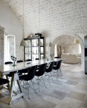 white brick going from the walls to the arched ceiling look bold with contemporary furniture in black creating an eclectic look