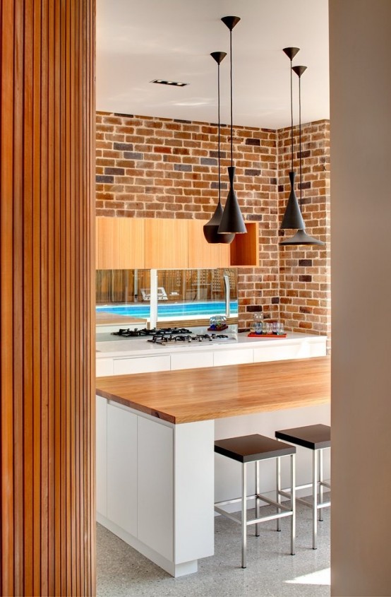 a brick wall makes the sleek modern space more relaxed and rustic and adds texture to it