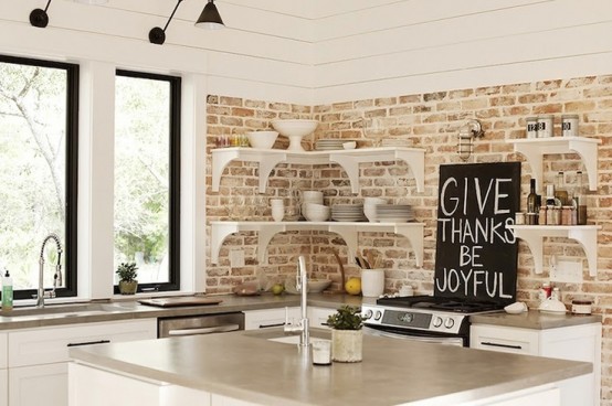 a neutral rustic kitchen with whitewashed bricks, white shelves and cabinets plus much natural light