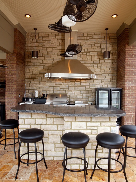 a faux stone wall and red brick pillars on each side make the kitchen bolder and bring a textural touch