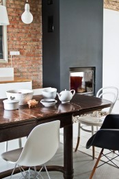 a red brick wall and a matte black hearth next to it to create a bold contrasting look that takes over the space