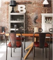 a distressed red brick wall in the dining zone and metal chairs mix up with refined and contemporary furniture for a unique look