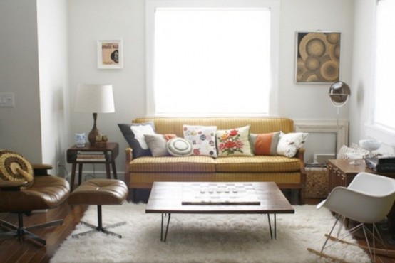 a neutral living room with mid-century modern furniture, artworks and a leather chair plus bright pillows