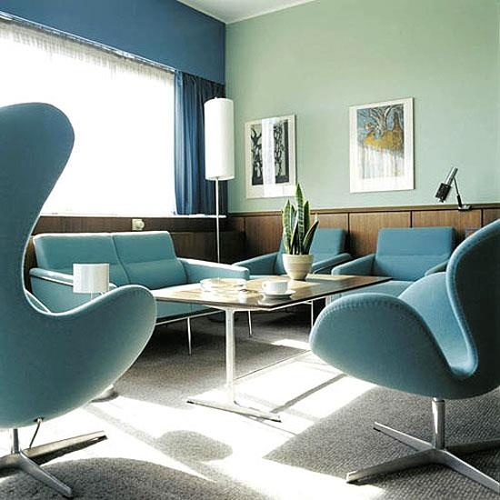 a blue and green living room with plywood panels, blue furniture and curtains and green walls