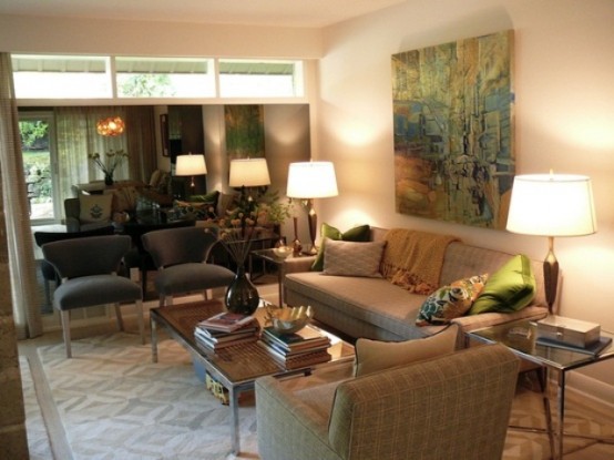 a neutral living room with an artwork, plaid furniture, prints and lamps for a welcoming and cozy look