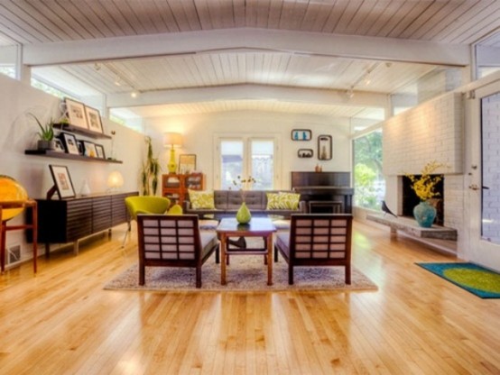 a neutral living room is spruced up with colorful touches - chairs, pillows and artworks plus rugs