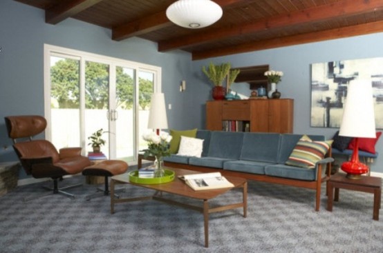 a grey living room done with a wooden ceiling, stained wooden furniture and bright colorful touches