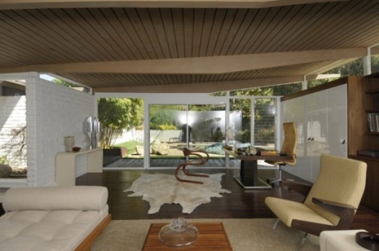 a neutral living room with creamy furniture, a faux animal skin, a wooden slab ceiling and sleek panels