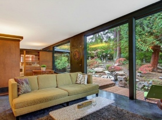 a bright mid-century modern living room with a green sofa, a terrazzo table and a fluffy rug