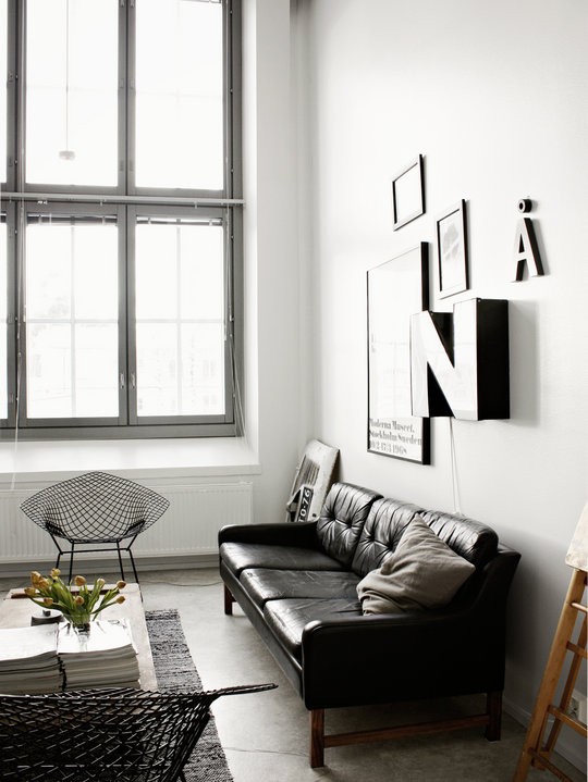 a Nordic meets mid-century living room done in a monochromatic color scheme and a cool gallery wall