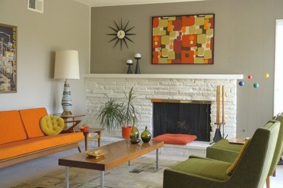 a space done in orange and green, with abstract prints, potted greenery and lamps