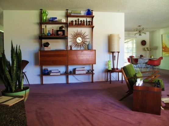 a mid-century modern space with a mauve rug, dark staiend furniture and potted plants