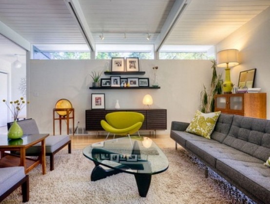 a cozy living room with grey furniture, touches of neon green and dark stained items and a skylight