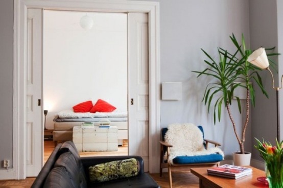 a bright mid-century modern living room with colorful furniture, potted greenery and lamps