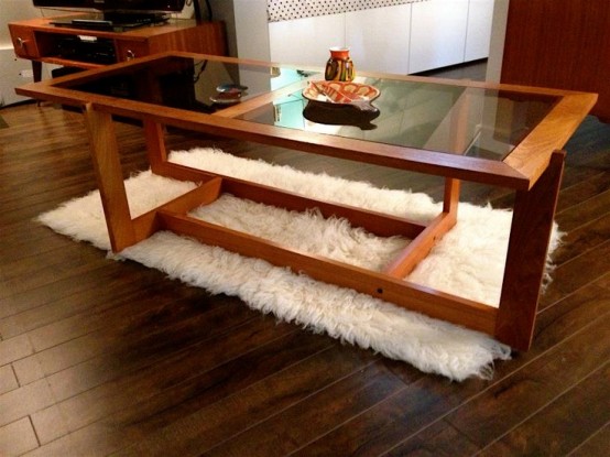 a large rich-stained coffee table with creatively shaped and placed legs and a large glass tabletop is always a very elegant idea