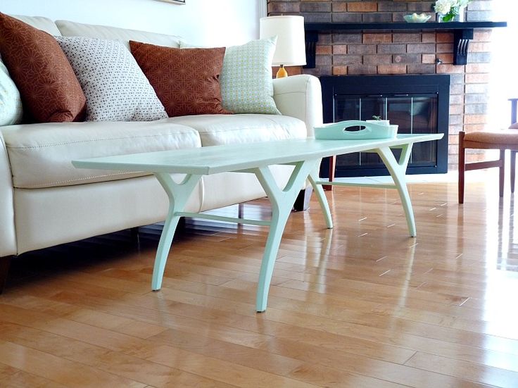 a mint colored coffee table on cool legs looks airy, it adds to the style and brings a soft touch of color to the room