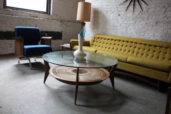 a two-tiered coffee table with a glass tabletop and a wooden second tabletop plus creatively placed legs