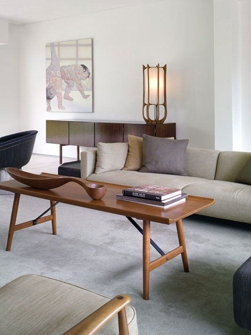 a light stained coffee table with trestle legs is a cool addition to mid century modern or refined modern interior