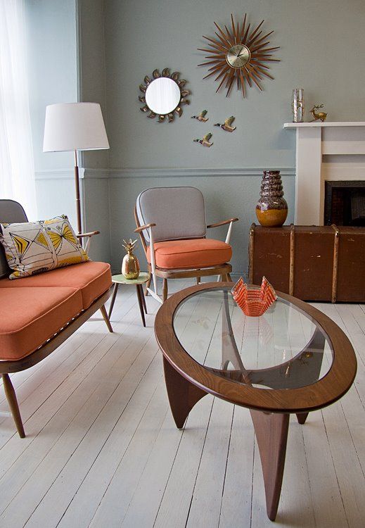 a chic mid-century modern coffee table with an oval glass tabletop and a creatively shaped base made of four legs