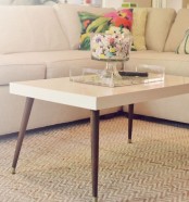 a mid-century modern coffee table with a white tabletop and dark-stained tapered legs is a lovely idea that will match most of interiors