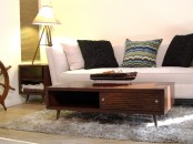 a rich-stained mid-century modern coffee table with a little drawer and an open storage compartment, on tapered legs is amazing and timeless