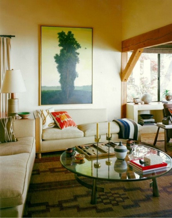 a classic round glass coffee table with metal legs is a beautiful and cool idea that can hold and display a lot of stuff and looks cool