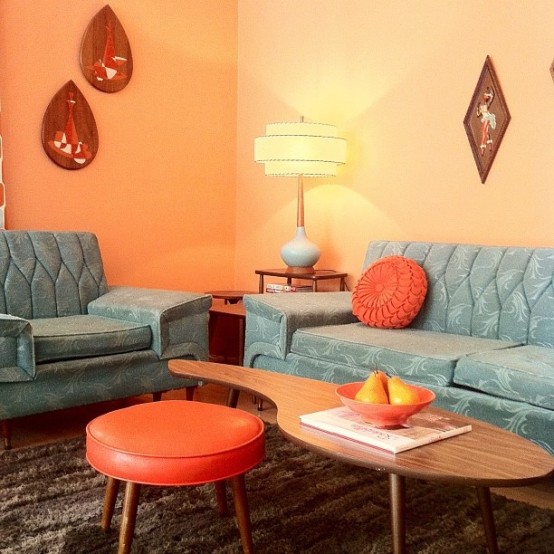 a creatively shaped rich-stained mid-century modern coffee table paired with a coral leather stool looks cool and catchy