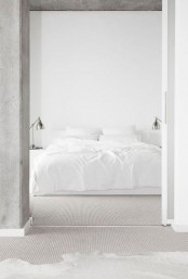 a white minimalist bedroom with a concrete ceiling, a bed with white bedding and metal table lamps is amazing