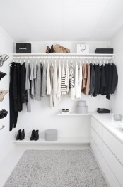 a white minimalist closet with shelves, shoe shelves and some dressers in white to store smaller things and accessories