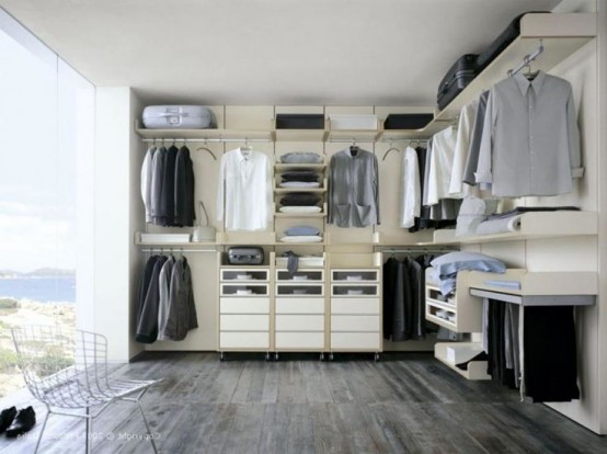 a minimalist closet with a glazed wall, open holders for clothes hangers and some shelves and drawers
