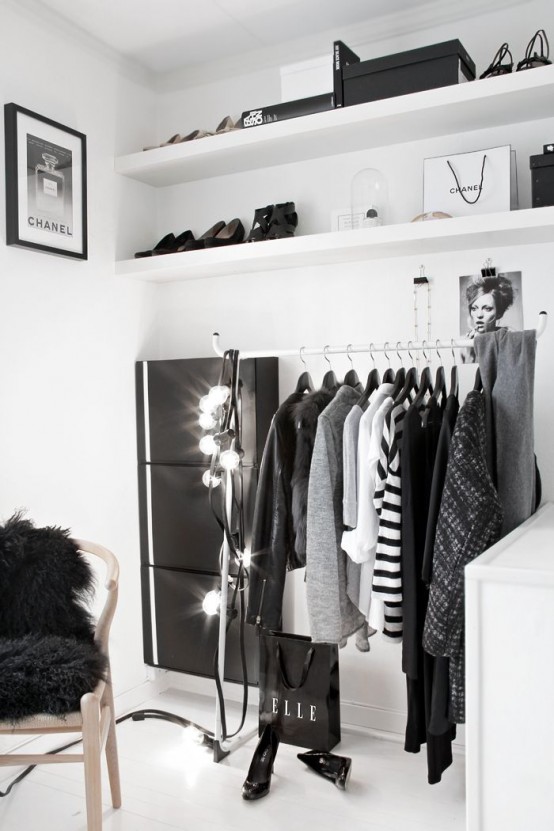 a minimalist white closet with a makeshift closet and open shelves plus lots of lights and a dresser
