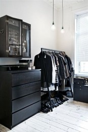 a very laconic black makeshift closet paired with some dressers and a unit for accessories placed in a corner