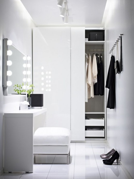 an ultra-minimalist closet in white with a storage unit with sliding doors, some drawers, a comfy makeup unit