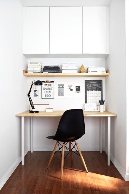 a small and cozy minimalist nook for working, with a small desk, a shelf and a cabinet for storage and a black chair has everything necessary