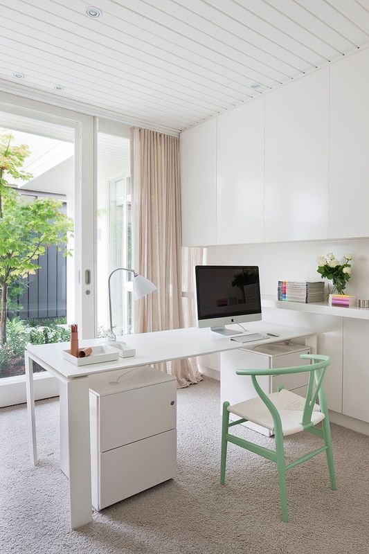 a minimalist home office with a view, a sleek white desk and storage cabinets, sleek storage units, a pastel green chair with a woven seat