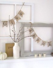 burlap buntings, a vase with a branch arrangement, white pumpkins and candleholders