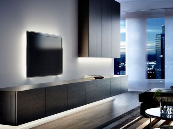 a storage system of dark-stained wooden storage units - on the wall on one side and under the TV