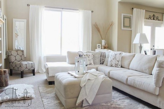 a neutral living room with beige walls, creamy seating furniture, upholstered ottomans and neutral linens is flowy and welcoming
