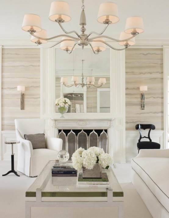 an exquisite neutral living room with catchy stone-like wallpaper, elegant white seating furniture, a glass coffee table and a fireplace with a chic screen, a pendant lamp